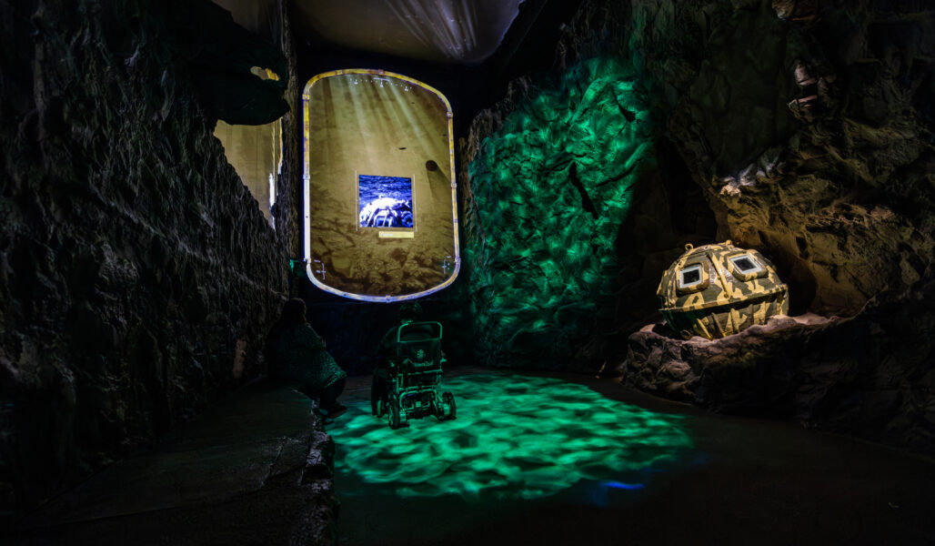 A visitor to The Loch Ness Centre, enjoying the immersive underwater Waters of the Loch experience in a wheelchair