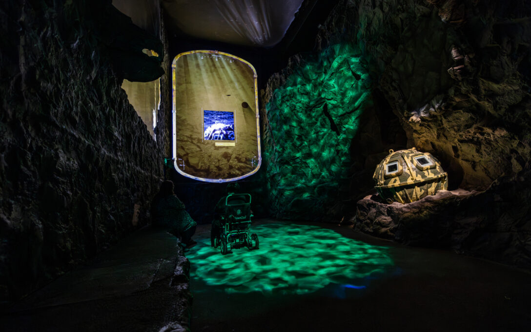 A visitor to The Loch Ness Centre, enjoying the immersive underwater Waters of the Loch experience in a wheelchair
