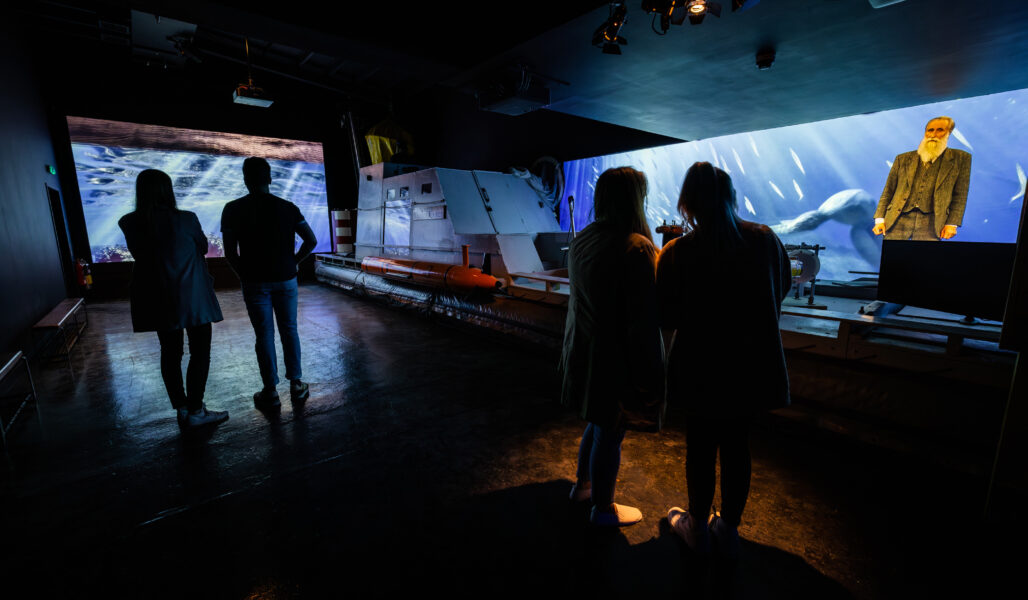 Groups of people in the search for truth room at the Loch Ness Centre, hearing the stories of the search for Nessie