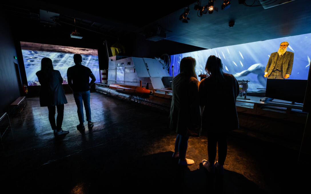 Groups of people in the search for truth room at the Loch Ness Centre, hearing the stories of the search for Nessie
